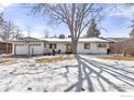 Inviting front exterior showcasing a brick home with an attached garage and a spacious yard partially covered in snow at 390 W 3Rd Ave Dr, Broomfield, CO 80020