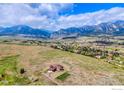 Panoramic aerial view of a residence with mountain views set in a vast natural landscape under a beautiful partly cloudy sky at 4702 Eldorado Springs Dr, Boulder, CO 80303