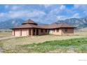 A serene one-story home with a two-car garage and beautiful mountain views under a partly cloudy blue sky at 4702 Eldorado Springs Dr, Boulder, CO 80303