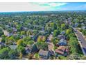 Expansive aerial view showcasing a neighborhood with lush greenery, various home styles, and a clear blue sky above at 510 Folklore Ave, Longmont, CO 80504