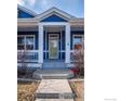 Close up of the home's entrance, with a covered porch, white railing, and charming front door at 5126 Mt Buchanan Ave, Frederick, CO 80504