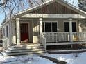 Inviting home with a spacious front porch, red door, and wintery landscape, perfect for relaxing outdoors at 535 Dewey Ave, Boulder, CO 80304