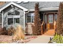 Inviting front entrance with wood door, brick accents, and a well-maintained landscape at 5393 Oak Tree Ct, Boulder, CO 80301