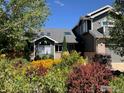 Beautifully landscaped front yard with mature trees and colorful flowerbeds at 5393 Oak Tree Ct, Boulder, CO 80301