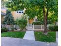 Charming two-story home featuring a well-manicured lawn, inviting walkway, and a white picket fence at 635 Gooseberry Dr # 1908, Longmont, CO 80503