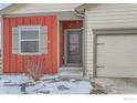 Close-up of a home's inviting front door and two-car garage, showcasing its exterior at 7333 Ellingwood Cir, Frederick, CO 80504