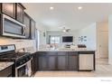 Modern kitchen with stainless steel appliances, granite countertops, and a breakfast bar at 7333 Ellingwood Cir, Frederick, CO 80504