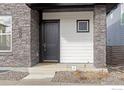 Close-up of the front entry with stone pillars and a dark-colored door at 735 Discovery Pkwy, Superior, CO 80027