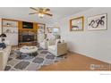 Cozy living room featuring a stone fireplace, built-in shelves, and comfortable seating at 9089 Vermillion Rd, Longmont, CO 80503