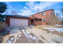 Two-story home with a two-car garage and a driveway that has some snow on it at 106 Granada Ct, Longmont, CO 80504