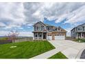 Two-story home featuring a manicured lawn, two car garage and a welcoming front porch at 1166 Ridgefield Dr, Berthoud, CO 80513