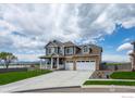 A two-story house displays its garage, manicured front yard, and a view of a lake at 1166 Ridgefield Dr, Berthoud, CO 80513