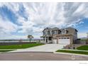 Two-story house with a two-car garage, manicured front yard and lake in the background at 1166 Ridgefield Dr, Berthoud, CO 80513