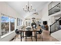 Bright dining room with vaulted ceilings, modern lighting, fireplace and large windows at 1495 Hickory Dr, Erie, CO 80516