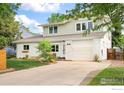 Charming two-story home with white brick, attached garage, landscaped yard, and concrete driveway at 1635 Quince Ave, Boulder, CO 80304