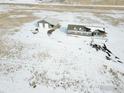 Aerial view of house and storage building in a snowy, open landscape at 17916 County Road 38, Platteville, CO 80651