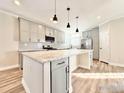 Modern kitchen featuring a large island, stainless steel appliances, and stylish light fixtures at 17916 County Road 38, Platteville, CO 80651