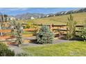 Landscaped yard with decorative trees and a rustic wooden fence at 18673 W 94Th Ln, Arvada, CO 80007