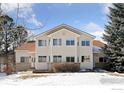 Well-maintained townhome with a classic facade, ample windows, and snowy front yard under a blue sky at 2143 Meadow Ct, Longmont, CO 80501