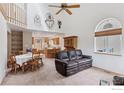 Spacious living room with high ceilings, bright windows, and a seamless open-concept layout to the kitchen and dining area at 2143 Meadow Ct, Longmont, CO 80501
