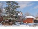 View of the side of the home, a two-car garage, mature trees, and a snow-covered lawn at 255 Iroquois Dr, Boulder, CO 80303