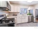 Contemporary kitchen with stainless steel appliances, sleek white cabinets, and a large window at 2994 23Rd St, Boulder, CO 80304
