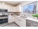 Modern kitchen featuring stainless steel appliances, white cabinets, and a bright window view at 2994 23Rd St, Boulder, CO 80304