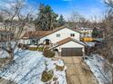 Charming two-story home featuring a well-manicured lawn and a two-car garage in a winter landscape at 3115 Heidelberg Dr, Boulder, CO 80305