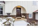 Elegant front entrance showcases a dark wood door under an arched portico, framed by brick accents at 3115 Heidelberg Dr, Boulder, CO 80305