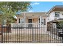 Charming home featuring a cozy front porch and a well-maintained yard enclosed by a classic black metal fence at 3244 Vallejo St, Denver, CO 80211