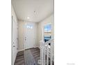 Bright entryway featuring a wood floor, white door with glass, and staircase at 350 High Point Dr # C201, Longmont, CO 80504