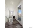 Hallway featuring a wood floor, white door with glass, and staircase at 350 High Point Dr # C201, Longmont, CO 80504