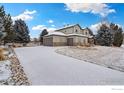 Exterior view of house showing three-car garage and snow-covered driveway at 4012 Milano Ln, Longmont, CO 80503