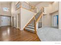 Open foyer with hardwood floors and a staircase with iron railings at 4012 Milano Ln, Longmont, CO 80503