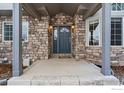 Inviting front entry with stone surround and covered porch at 4012 Milano Ln, Longmont, CO 80503