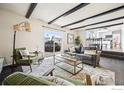 Sun-filled living room with beamed ceilings, hardwood floors, and sliding glass doors to the backyard at 440 E Sutton Cir, Lafayette, CO 80026