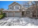 Charming two-story home with a stone facade and attached two-car garage in winter at 4672 Charing Ct, Castle Rock, CO 80109