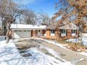 Charming single-Gathering home featuring a brick facade, attached garage, and a snowy front yard at 4760 Mckinley Dr, Boulder, CO 80303