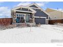 Charming single Gathering home with blue siding and stone accents, covered front porch, and attached garage at 490 N Ider Way, Aurora, CO 80018