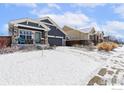 Charming single Gathering home with blue siding, stone accents, a covered front porch, and attached garage at 490 N Ider Way, Aurora, CO 80018