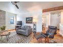 Open-concept living room with stone fireplace, wood floors, and a comfortable armchair at 525 Manhattan Dr # 104, Boulder, CO 80303