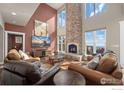 Elegant living room featuring high ceilings, stone fireplace, comfortable leather furniture and scenic views at 820 Peakview Rd, Boulder, CO 80302