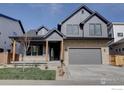 Modern two-story home featuring a stone facade, gray siding, and a two-car garage at 913 Saint Andrews Ln, Louisville, CO 80027