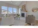 Bright living room with vaulted ceilings, fireplace, large windows, and modern decor at 964 Saint Andrews Ln, Louisville, CO 80027