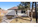 Charming single-Gathering home with tidy lawn and concrete walkway leading to the front door and a brown shingle roof at 972 S Zeno Way, Aurora, CO 80017
