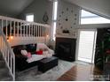 Inviting living room with a vaulted ceiling, cozy fireplace, and staircase to loft at 972 S Zeno Way, Aurora, CO 80017