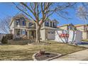 Two-story home featuring a well-manicured lawn and an inviting front porch with decorative seating at 9757 Kipling St, Broomfield, CO 80021