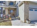 Inviting entrance featuring a glass paneled front door and a cozy seating area with decorative flower pots at 9757 Kipling St, Broomfield, CO 80021