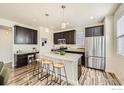 Modern kitchen featuring granite countertops, dark wood cabinets, and stainless steel appliances at 11225 Colony Cir, Broomfield, CO 80021