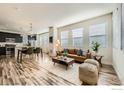 Bright, open-concept living room with hardwood floors, leading into kitchen and dining areas at 11225 Colony Cir, Broomfield, CO 80021